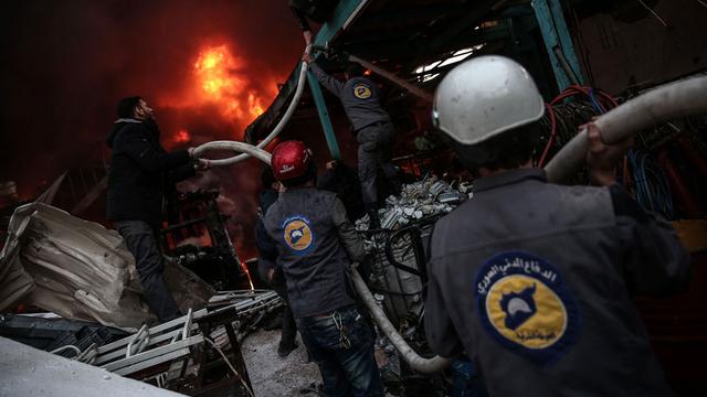 Les membres de la Défense civile syrienne, ou Casques blancs, portent secours aux victimes. [AFP - Sameer Al-Doumy]