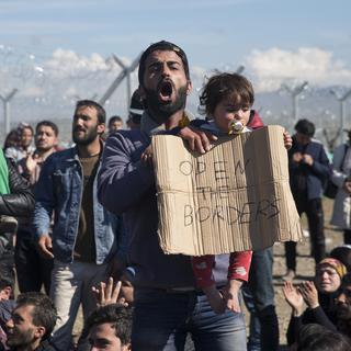 Des réfugiés bloqués au poste-frontière d'Idomeni entre la Grèce et la Macédoine. [AP Photo/Petros Giannakouris]