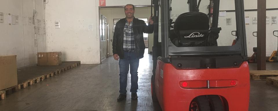 Angel Rodriguez, d'abord venu comme saisonnier en Suisse, est à la tête d'une entreprise de transport qui emploie 102 personnes. [RTS - Nicolae Schiau]