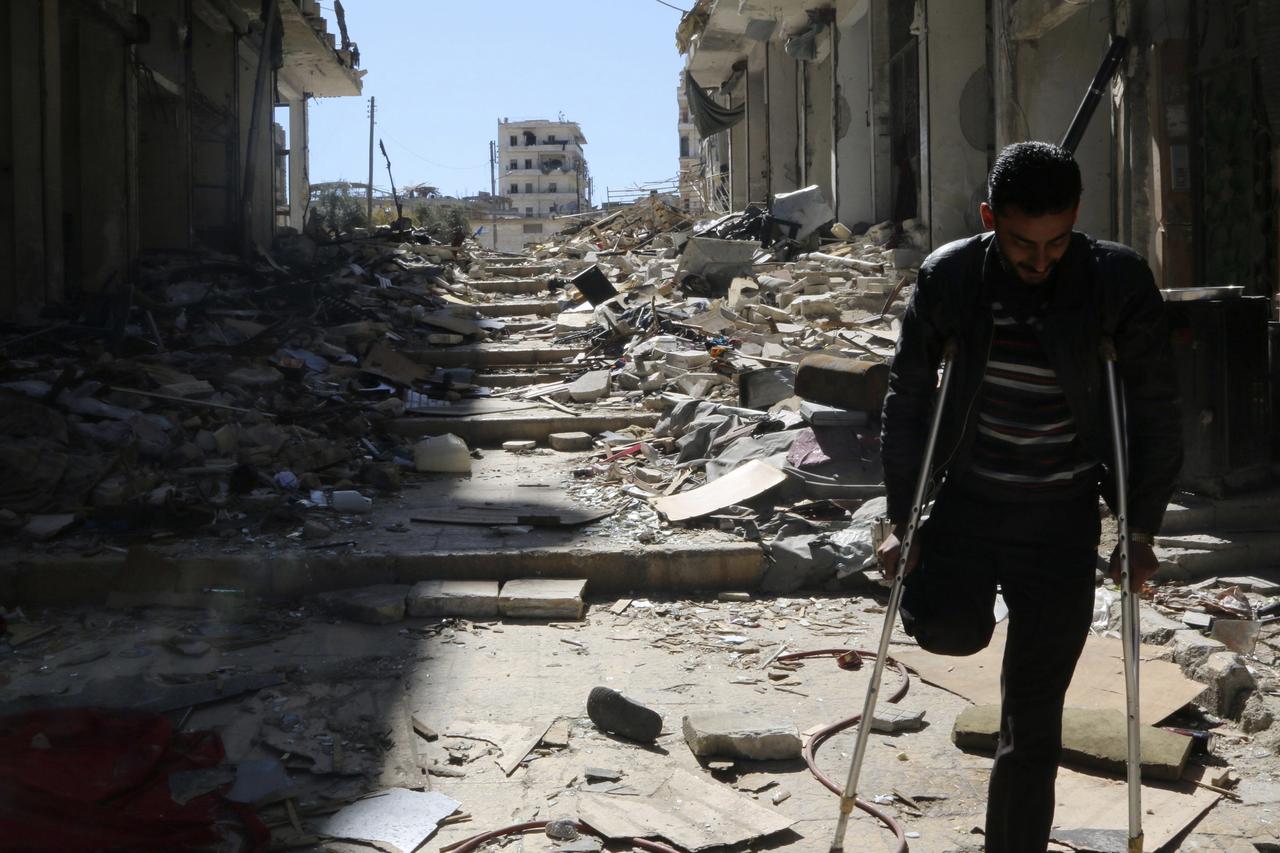 Un homme handicapé marche dans une rue détruite d'Alep. [REUTERS - Mahmoud Hebbo]