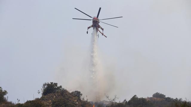 Un hélicoptère largue de l'eau sur un foyer d'incendie en Californie, ce 16 juin 2016. [AP Photo/Nick U]