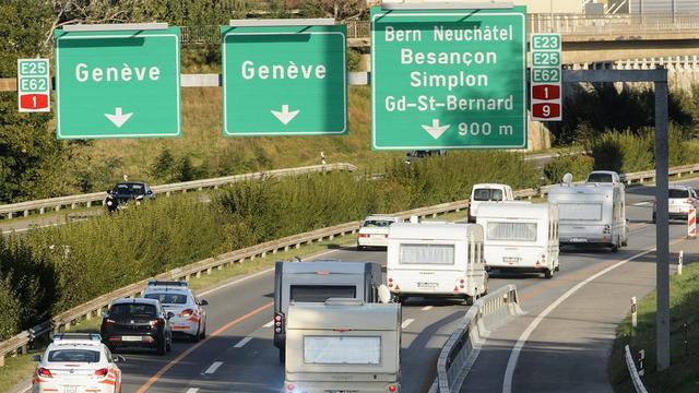 Des policiers escortent des caravanes après leur évacuation suite au stationnement illégale dans un champs de l'Etat de Vaud en septembre 2012. [Laurent Gillieron]