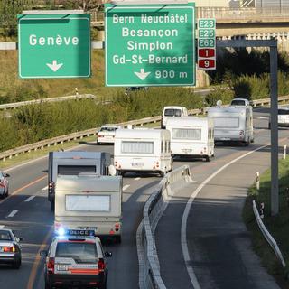 Des policiers escortent des caravanes après leur évacuation suite au stationnement illégale dans un champs de l'Etat de Vaud en septembre 2012. [Laurent Gillieron]