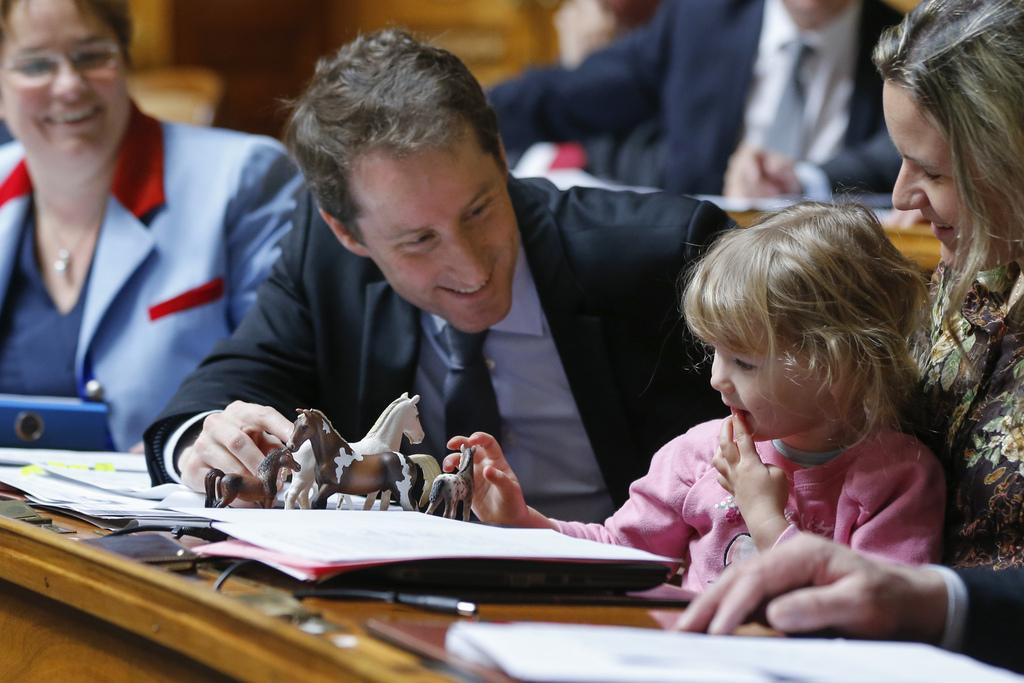 La fille d'Andrea Geissbuehler (UDC-BE) sur les genoux de sa mère, à côté de Thomas Aeschi (UDC-ZG). [KEYSTONE - Peter Klaunzer]