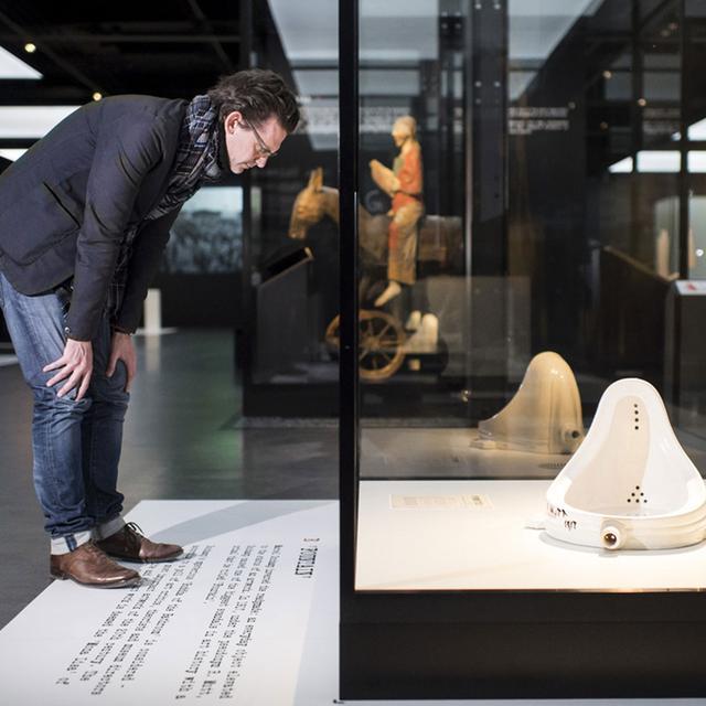 Juri Steiner devant la "Fontaine" de Marcel Duchamp présentée lors de l'exposition "Dada Universel" au musée national de Zurich. [Keystone - Ennio Leanza]