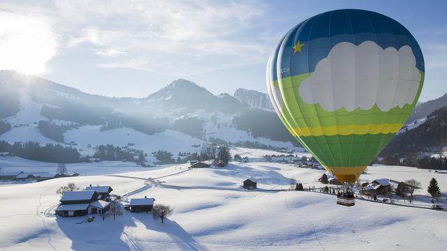 Plus de 70 montgolfières dans le ciel de Château d'Oex. [Keystone - Cyril Zingaro]