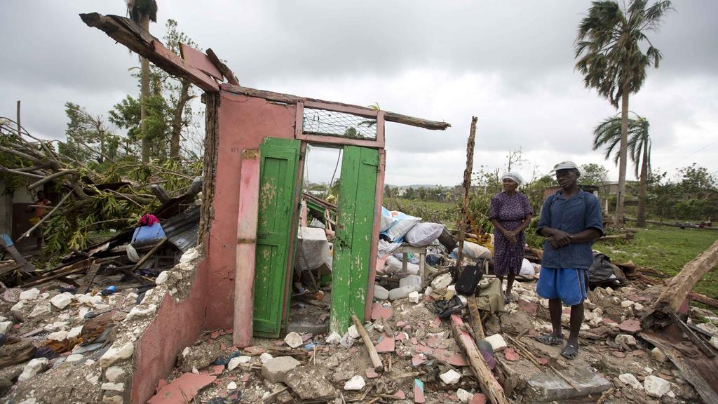Des habitants regardent les ruines de leur maison après le passage de l'ouragan Matthew le 6 octobre 2016 à Les Cayes, en Haïti. [Keystone - AP Photo/Dieu Nalio Chery]