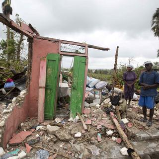 Des habitants regardent les ruines de leur maison après le passage de l'ouragan Matthew le 6 octobre 2016 à Les Cayes, en Haïti. [Keystone - AP Photo/Dieu Nalio Chery]