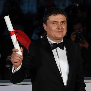Cristian Mungiu reçoit le Prix de la Mise en scène pour "Baccalauréat" au Festival de Cannes, mai 2016. [AFP - Anne-Christine Poujoulat]