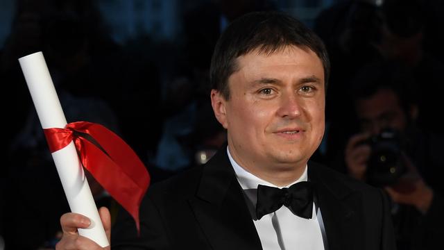 Cristian Mungiu reçoit le Prix de la Mise en scène pour "Baccalauréat" au Festival de Cannes, mai 2016. [AFP - Anne-Christine Poujoulat]