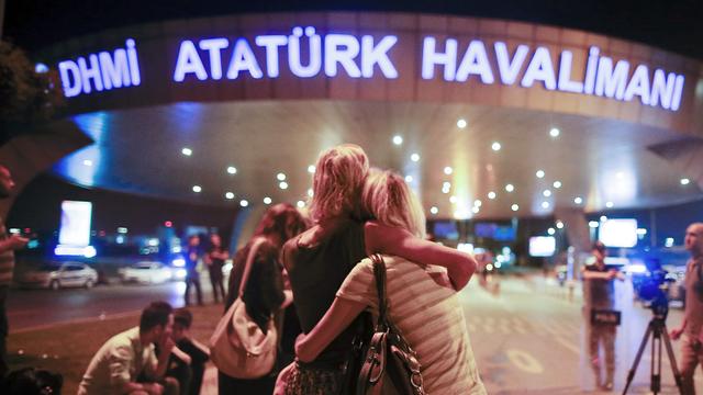 Des passagers se prennent dans les bras devant l'aéroport d'Istanbul. [Keystone - Emrah Gurel]