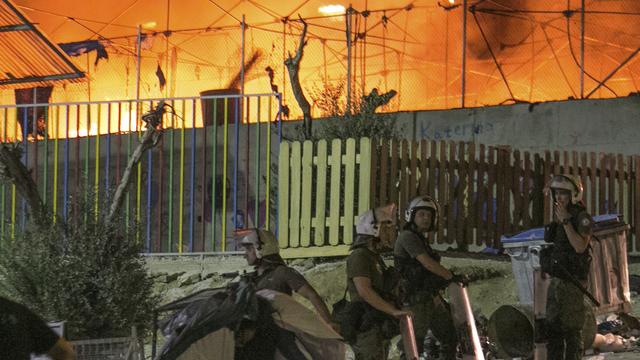 Policiers grecs sécurisant les environs du camp en flammes de Moria sur l'île de Lesbos, où le sinistre semble être d'origine volontaire.