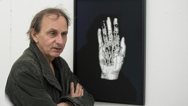 L'écrivain et artiste Michel Houellebecq à côté d'une de ses oeuvres dans le cadre de "Manifesta". [Keystone - Ennie Leanza]