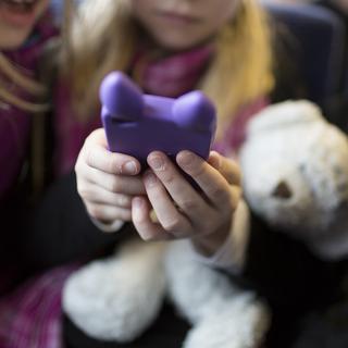 Une enfant utilise un smartphone. [Keystone - Gaëtan Bally]
