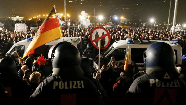 Une manifestation organisée par le mouvement d'extrême droite Pegida passe devant des opposants à Pegida à Dresde. [Fabrizio Bensch]