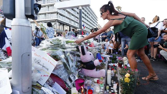 Des anonymes se recueillent sur la promenade des Anglais à Nice. [Keystone - IAN LANGSDON]