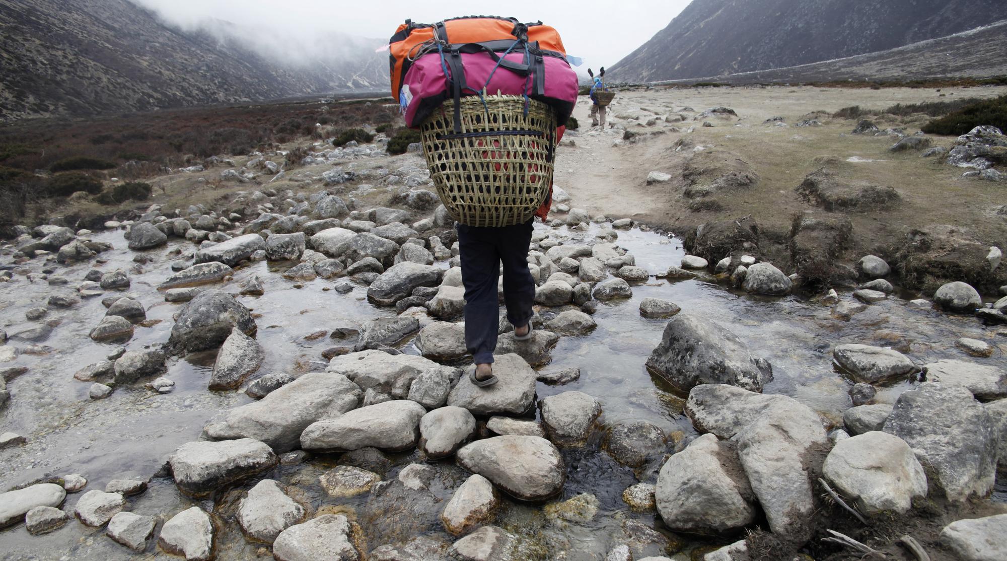 Un porteur transportant les bagages de touristes à travers le village de Periche, sur le Mont Everest. [Reuters - © Laurence Tan / Reuters]