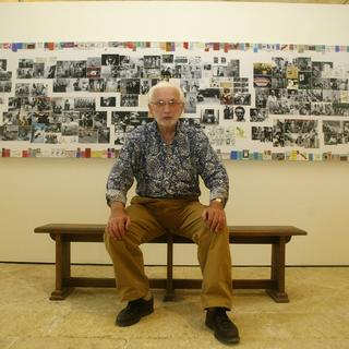 Le photographe français Lucien Clergue pose devant un collage représentant toute sa carrière, le 06 juillet 2004 a l'Abbaye de Montmajour à Arles. [AFP - Dominique Faget]