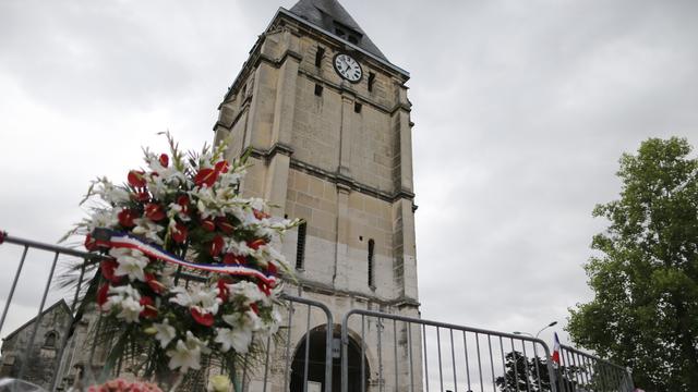 Des fleurs ont été déposées devant l'église où a eu lieu un attentat mardi. [AFP - Charly Triballeau]