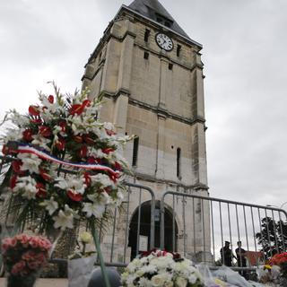 Des fleurs ont été déposées devant l'église où a eu lieu un attentat mardi. [AFP - Charly Triballeau]
