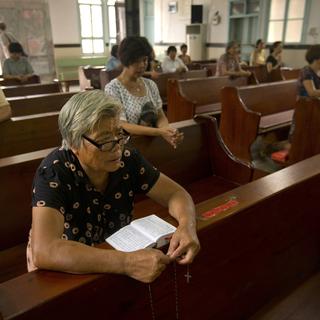 Des Chrétiens chinois se recueillent dans une église. [AP Photo/Keystone - Mark Schiefelbein]