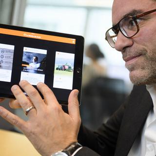 Le rédacteur en chef du "Matin" Gregoire Nappey pose avec la première édition du journal numérique "Le Matin du Soir" ce lundi 31 octobre 2016. [Keystone - Laurent Gillieron]