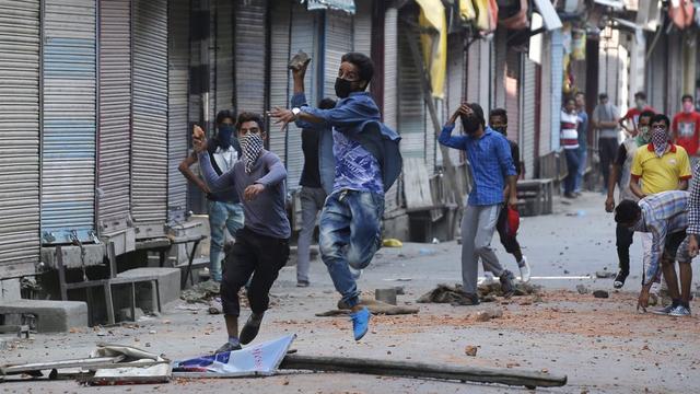 Des manifestants musulmans du Cachemire lancent des pierres sur des policiers indiens [EPA - FAROOQ KHAN]