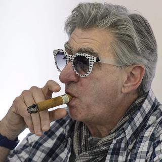 Jeudi 10 mars: Le CEO de Swatch Nick Hayek fume un cigare au cours de la conférence de presse du géant horloger à Bienne. [Keystone - Jean-Christophe Bott]