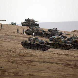 Chars turcs positionnés  la frontière avec la Syrie. [AP/Keystone - Lefteris Pitarakis]