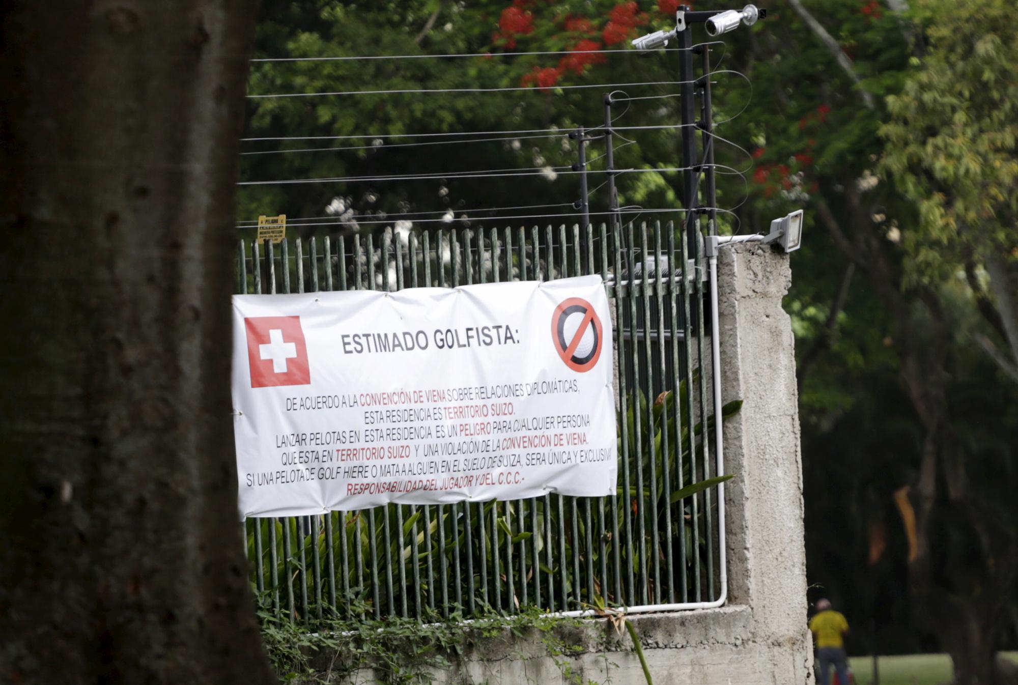 Une affiche avertissant les joueurs du terrain de golf voisin de l'ambassade de Suisse au Venezuela. [reu - Jorge Dan Lopez]