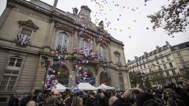 Sur le parvis de la mairie du 11e arrondissement, un lâcher de ballons en hommage aux victimes a eu lieu en milieu de journée dimanche. [KEYSTONE - EPA/ETIENNE LAURENT]