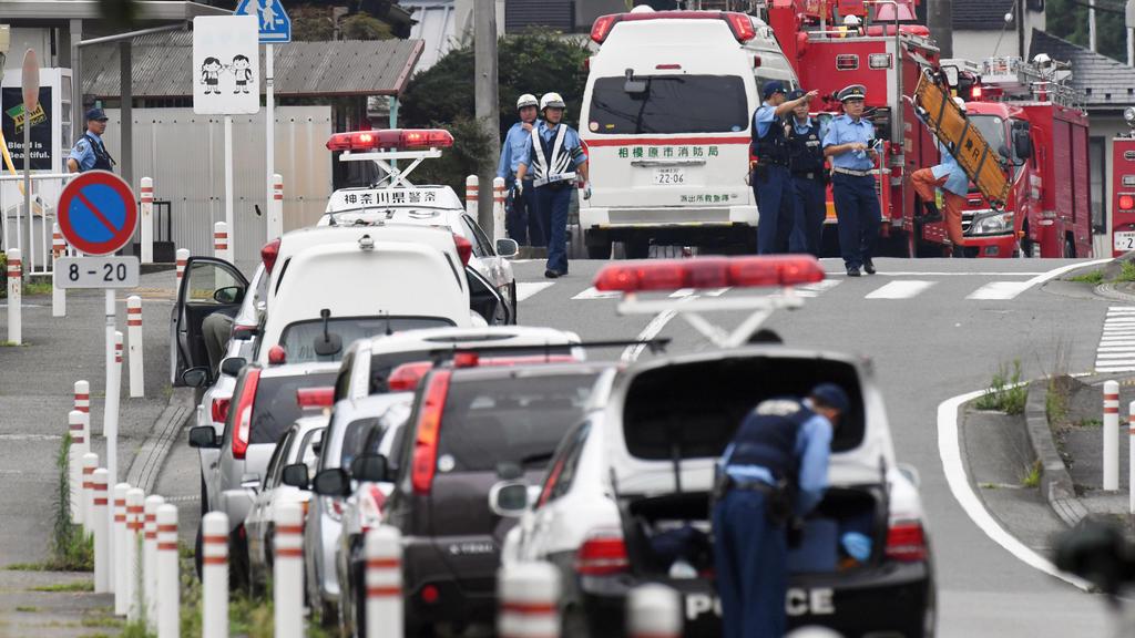Des ambulances et secouristes japonais se tiennent devant le centre pour handicapés de Sagamihara, au sud-ouest de Tokyo, qui a été attaqué par un de ses employés armé d'un couteau dans la nuit de lundi à mardi. [Keystone]