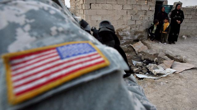 Femmes et enfants irakiens observant un militaire américain, Bagdad. [AFP]
