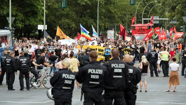 Des manifestants soutenant la politique d'accueil des migrants. [Keystone - EPA/JOERG CARSTENSEN]