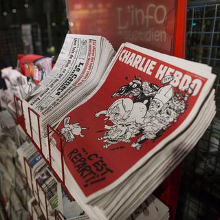 Des exemplaires de l'hebdomadaire Charlie Hebdo dans un kiosque à Paris. [KEYSTONE - IAN LANGSDON]