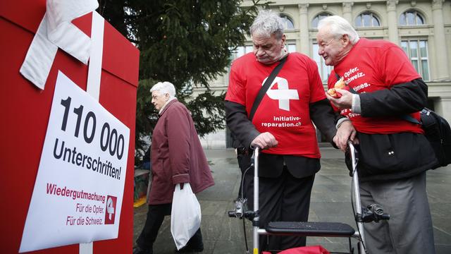 Charles et Fritz Probst, anciens enfants placés, ici lors du dépôt de l'initiative pour la réparation en 2014. [Keystone - Peter Klaunzer]