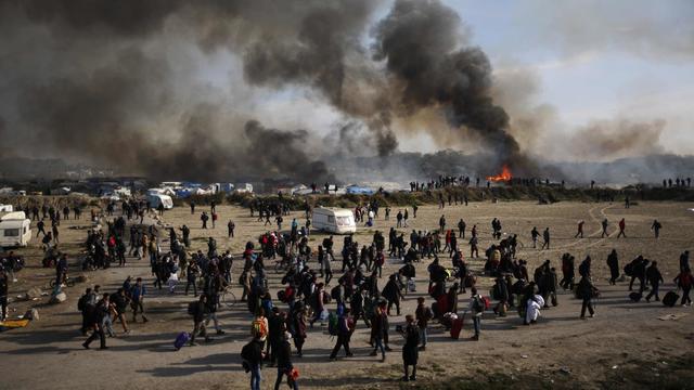 Les migrants quittent la "jungle" de Calais alors que se multiplient les foyers d'incendie dans le bidonville. [AP Photo/Emilio Morenatti]