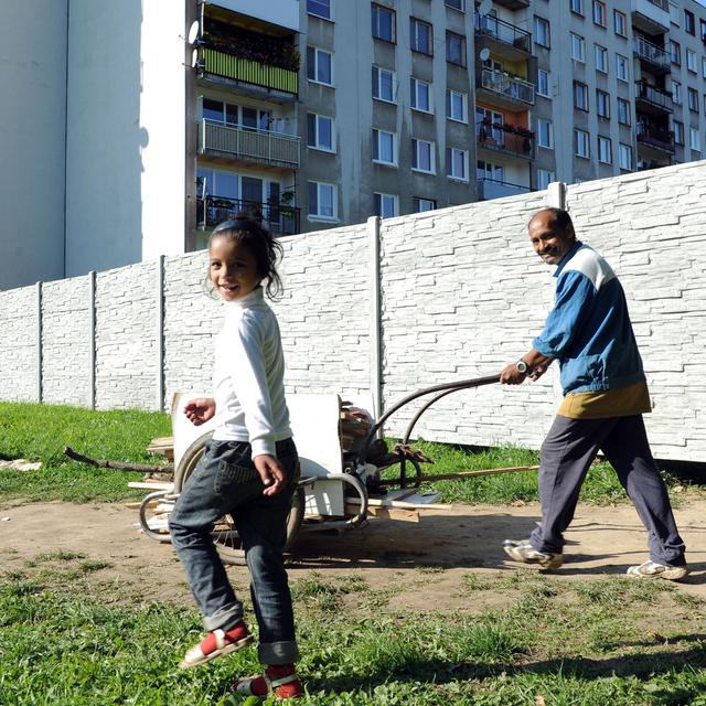 Un père de famille et sa fille longent le mur "anti-roms" érigé à Michalovce, à l'est de la Slovaquie. [AFP - Samuel Kubani]