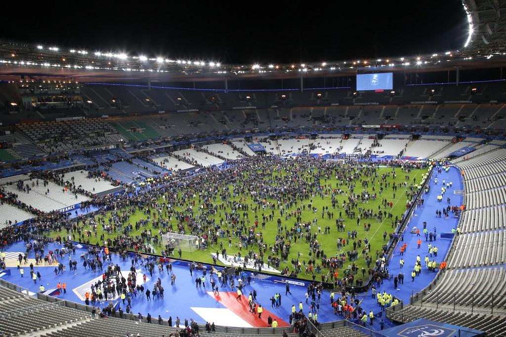 Le Stade de France, à la fin du match France-Allemagne, le 13 novembre 2015. Les spectateurs restent sur la pelouse après les explosions entendues à l'extérieur. [AP/Keystone - Michel Euler]
