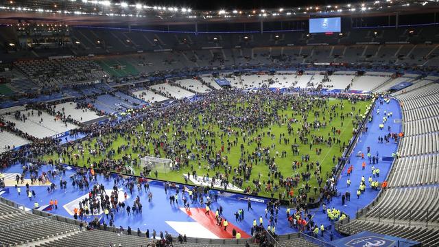 Le Stade de France, à la fin du match France-Allemagne, le 13 novembre 2015. Les spectateurs restent sur la pelouse après les explosions entendues à l'extérieur. [AP/Keystone - Michel Euler]