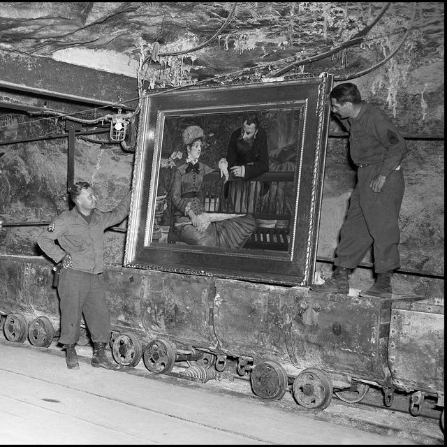Des "Monuments men" retrouvent dans la mine de Merkers en Thuringe en Allemagne la toile de Manet "Dans la serre" le 25 avril 1945. [Leemage / AFP]