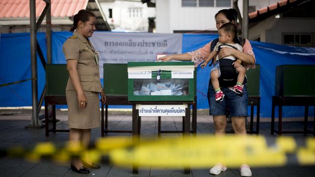 Une Thaïlandaise dépose son bulletin dans l'urne dans un bureau de vote de Bangkok, le 7 août 2016. [AFP - BORJA SANCHEZ-TRILLO]