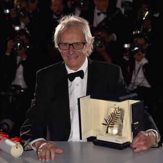 Ken Loach pose avec la Palme d'or qu'il a gagné pour "Moi, Daniel Blake", 22 mai 2016. [AFP - Loïc Venance]