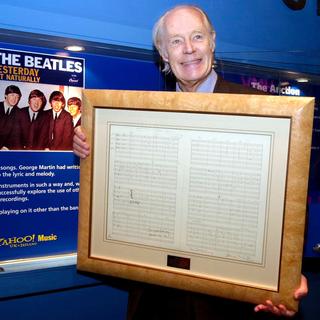 En 2001, Sir George Martin tient l'original de la chanson "Yesterday", écrite en 1965. [AP Photo/PA/Fiona Hanson]