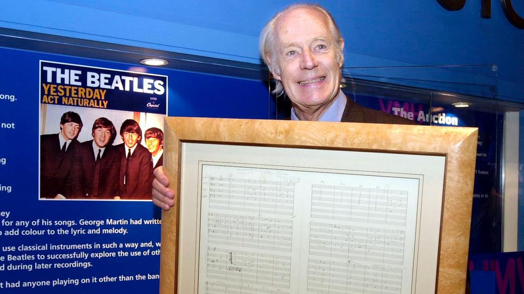 En 2001, Sir George Martin tient l'original de la chanson "Yesterday", écrite en 1965. [AP Photo/PA/Fiona Hanson]