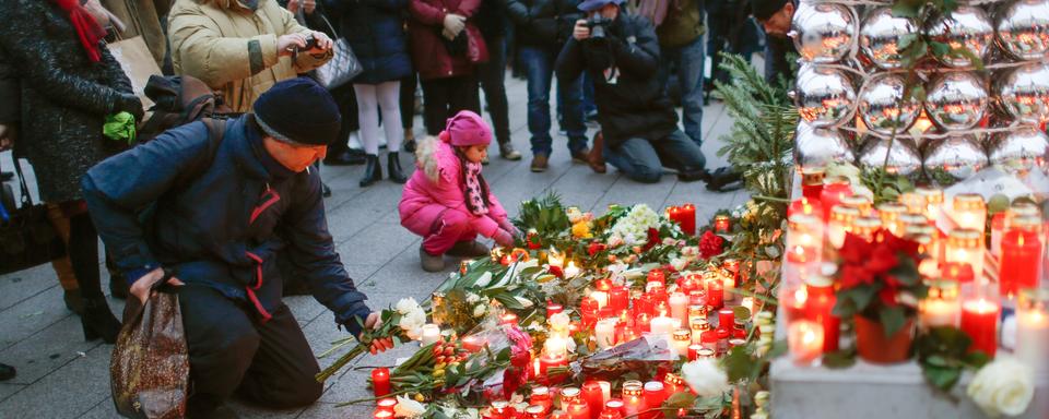 Des personnes sont venues rendre hommage aux victimes mardi, au marché de Noël de Berlin. [reuters - Hannibal Hanschke]