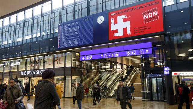 L'affiche fondant la croix helvétique dans la croix gammée sera retirée de la gare Cornavin, à Genève. [Keystone - Salvatore Di Nolfi]