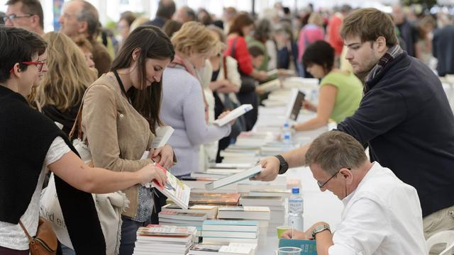 Un auteur effectue des dédicaces lors de la 6e édition de Livre sur les Quais. [Keystone - Laurent Gillieron]