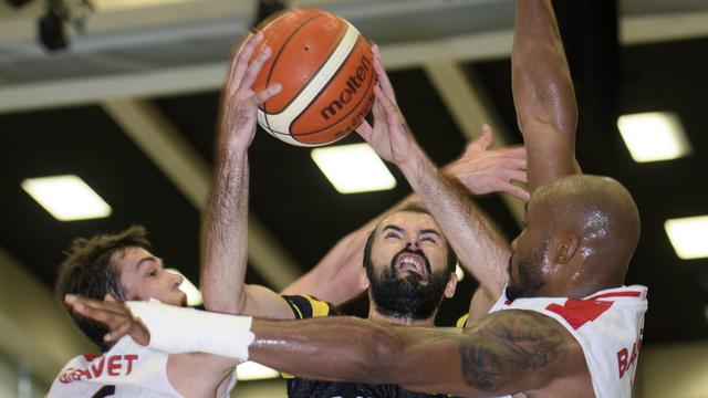 Pankracije Barac, le joueur de Monthey au centre, lutte avec Paul Gravet (gauche) et Brandon Young (droite). [Martial Trezzini]