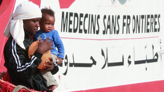 Un migrant et un enfant descendent du bateau Vox Prudence de l'ONG Médecins sans frontières le 14 juillet 2017. [AFP - CARLO HERMANN]